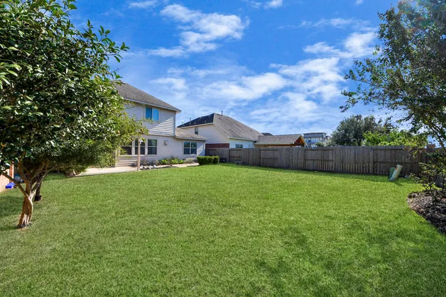 a kitchen with stainless steel appliances granite countertop a refrigerator a stove top oven and a sink with granite countertops