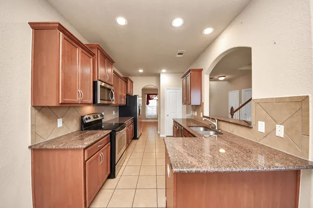 a kitchen with stainless steel appliances granite countertop a sink stove and cabinets