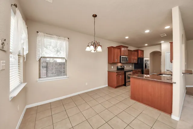 a view of an empty room with chandelier fan and a fireplace