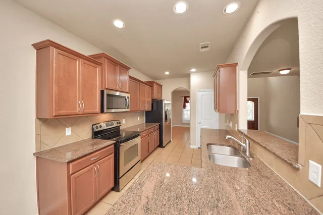 a view of an empty room with a fireplace and a window