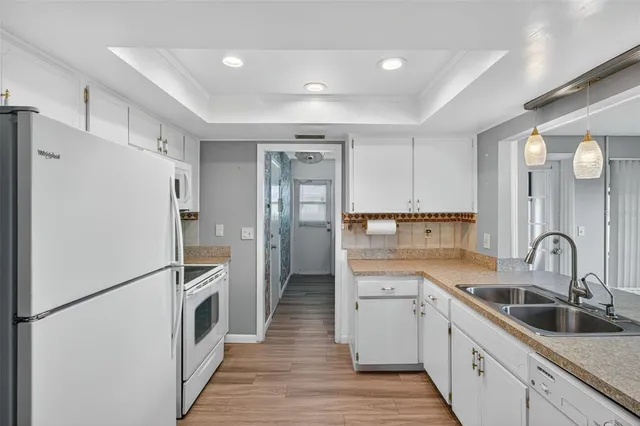 a kitchen with a refrigerator sink and cabinets