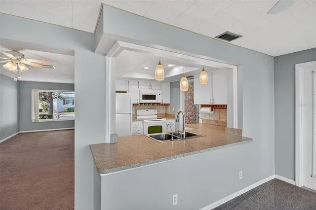 a kitchen with kitchen island sink stove and refrigerator