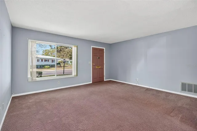 an empty room with windows and closet