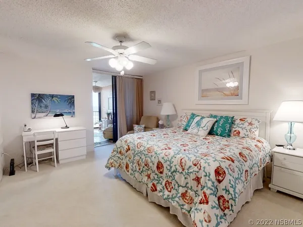 a spacious bedroom with a bed and a chandelier