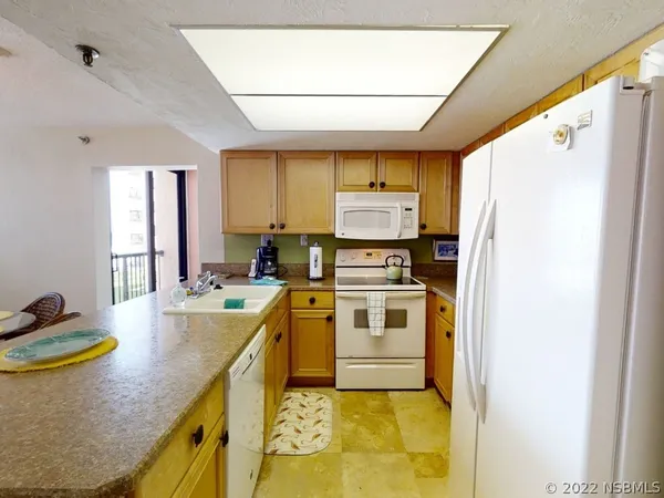 a kitchen with stainless steel appliances granite countertop a sink a stove a refrigerator with grey cabinets