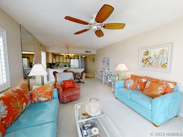 a living room with furniture kitchen view and a window