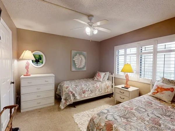 a bedroom with two beds and a chandelier