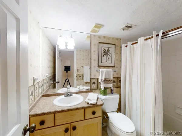 a bathroom with a granite countertop sink mirror vanity and toilet