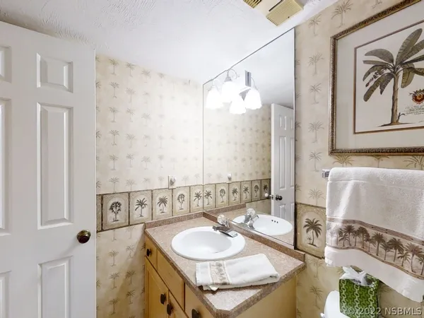 a bathroom with a granite countertop sink a mirror and a shower