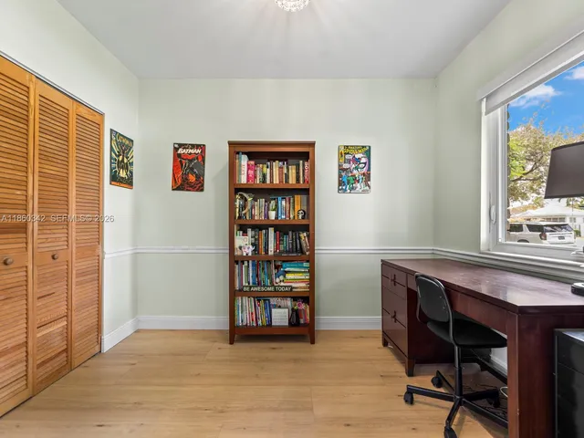 a view of a workspace with furniture and a window
