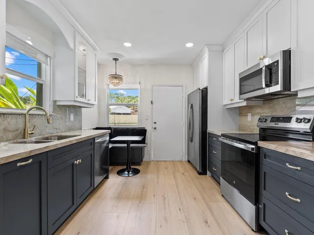a kitchen with stainless steel appliances a stove sink microwave and cabinets