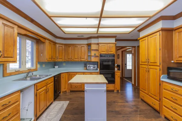 a kitchen with stainless steel appliances granite countertop a sink and wooden cabinets