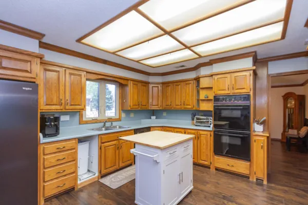 a kitchen with stainless steel appliances granite countertop a sink and wooden cabinets