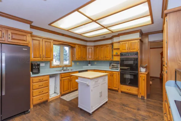 a kitchen with stainless steel appliances granite countertop a sink and a refrigerator