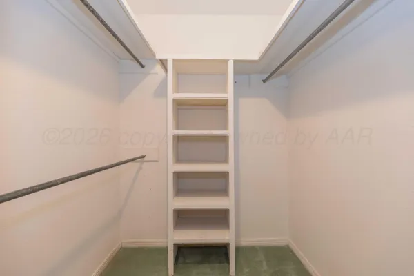 a view of walk in closet with empty racks