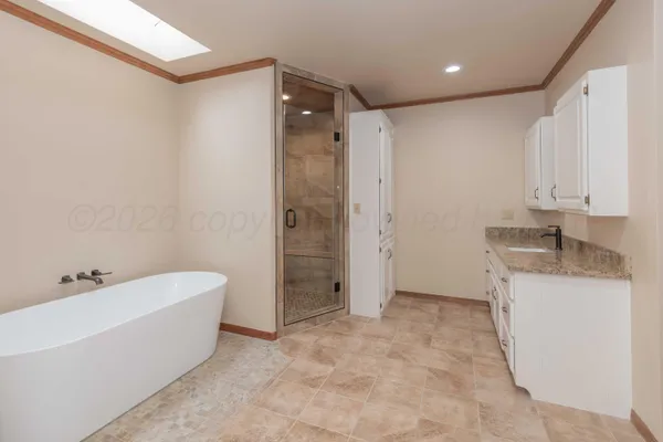 a bathroom with a granite countertop sink a mirror and a bathtub