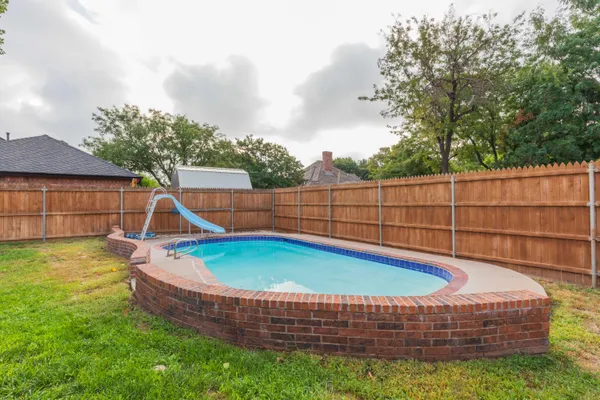 a view of a backyard with swimming pool and deck