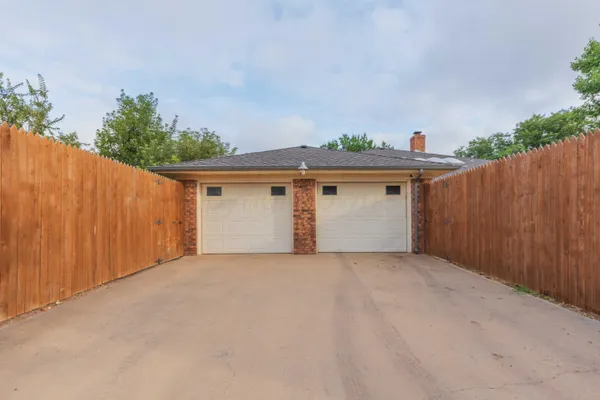 a view of a white house with wooden fence