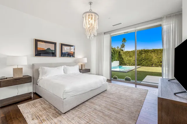 a spacious bedroom with a bed and a flat screen tv