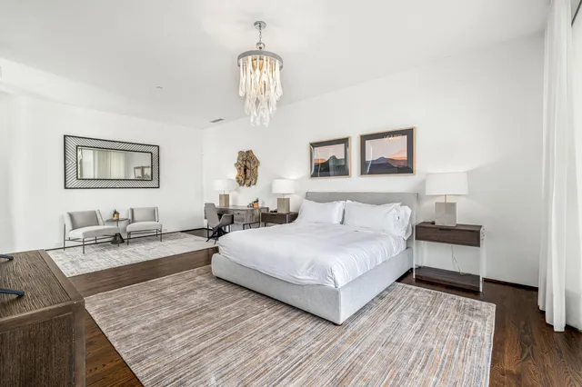 a bedroom with a bed and a chandelier