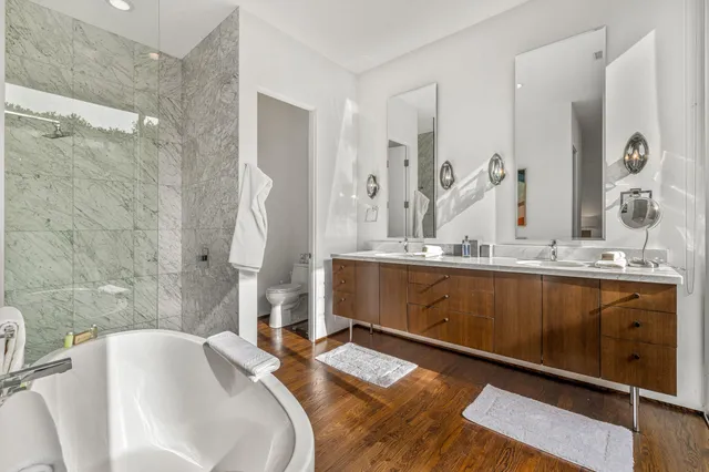 a spacious bathroom with double vanity sinks a bathtub and a shower