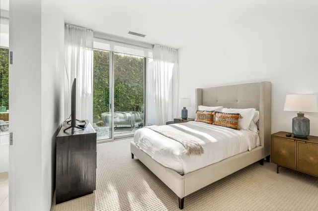 a bedroom with a bed and large window