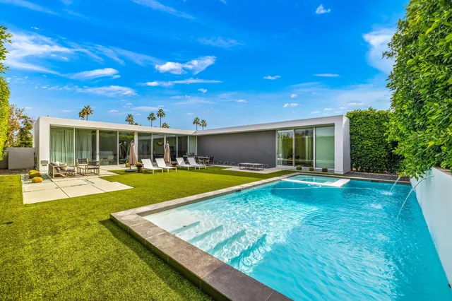 a view of an house with swimming pool and porch with furniture