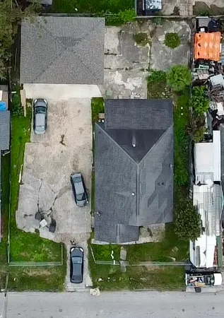 an aerial view of a house with a yard and a large tree