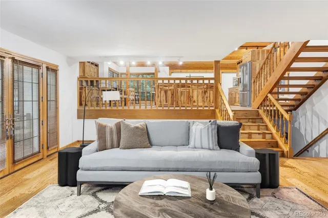 a living room with furniture cabinets and wooden floor