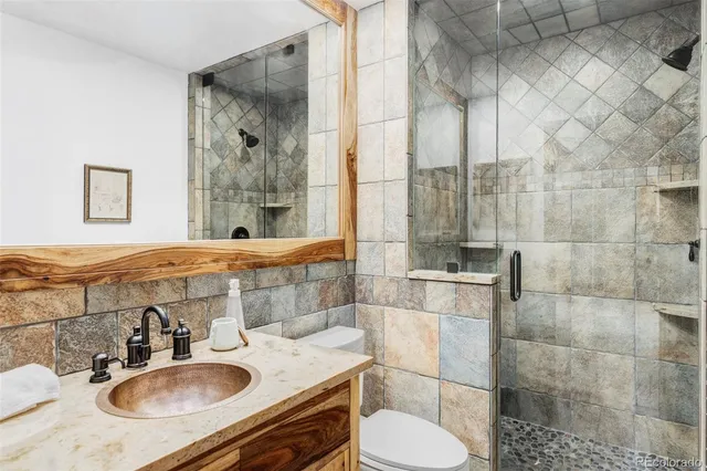 a bathroom with a sink toilet a mirror and shower