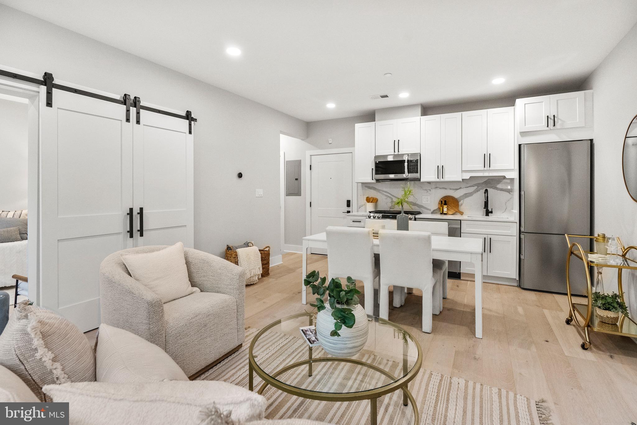 2019 M Street Northeast, Unit 1 Washington, DC 20002 - Photo 10 of 31 a living room with furniture a refrigerator and kitchen view