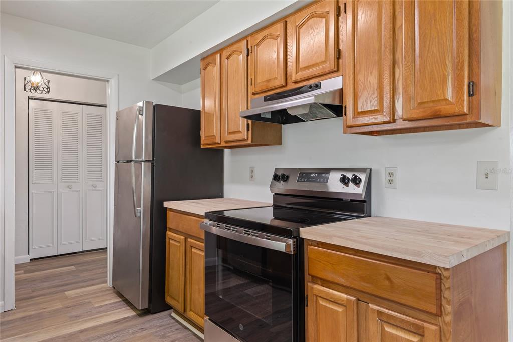 6401 Southwest 78th Street Gainesville, FL 32608 - Photo 5 of 29 a kitchen with stainless steel appliances granite countertop a refrigerator stove a sink and dishwasher with wooden floor