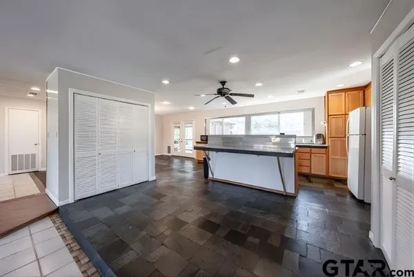 a large kitchen with stainless steel appliances granite countertop a refrigerator and a sink