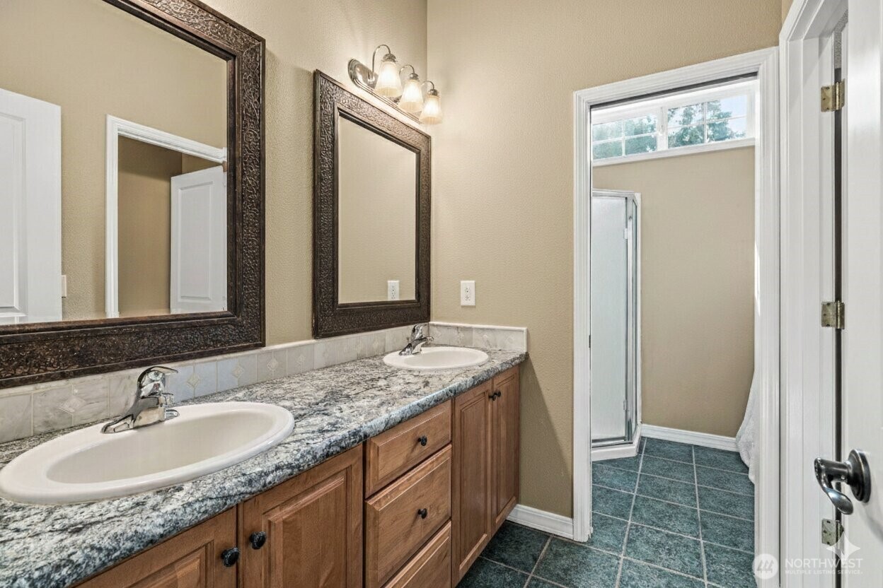 9609 346th Street South Roy, WA 98580 - Photo 16 of 31 a bathroom with a granite countertop double vanity sink and a mirror