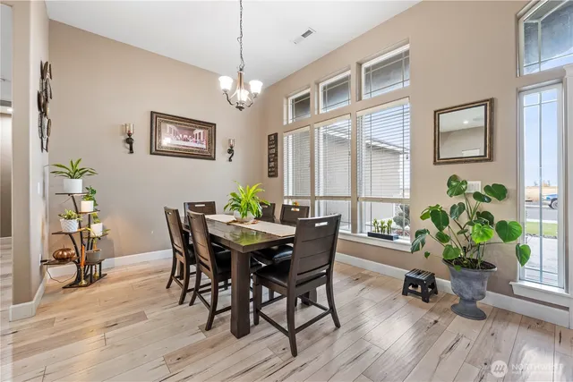 a dining room with furniture potted plants and wooden floor
