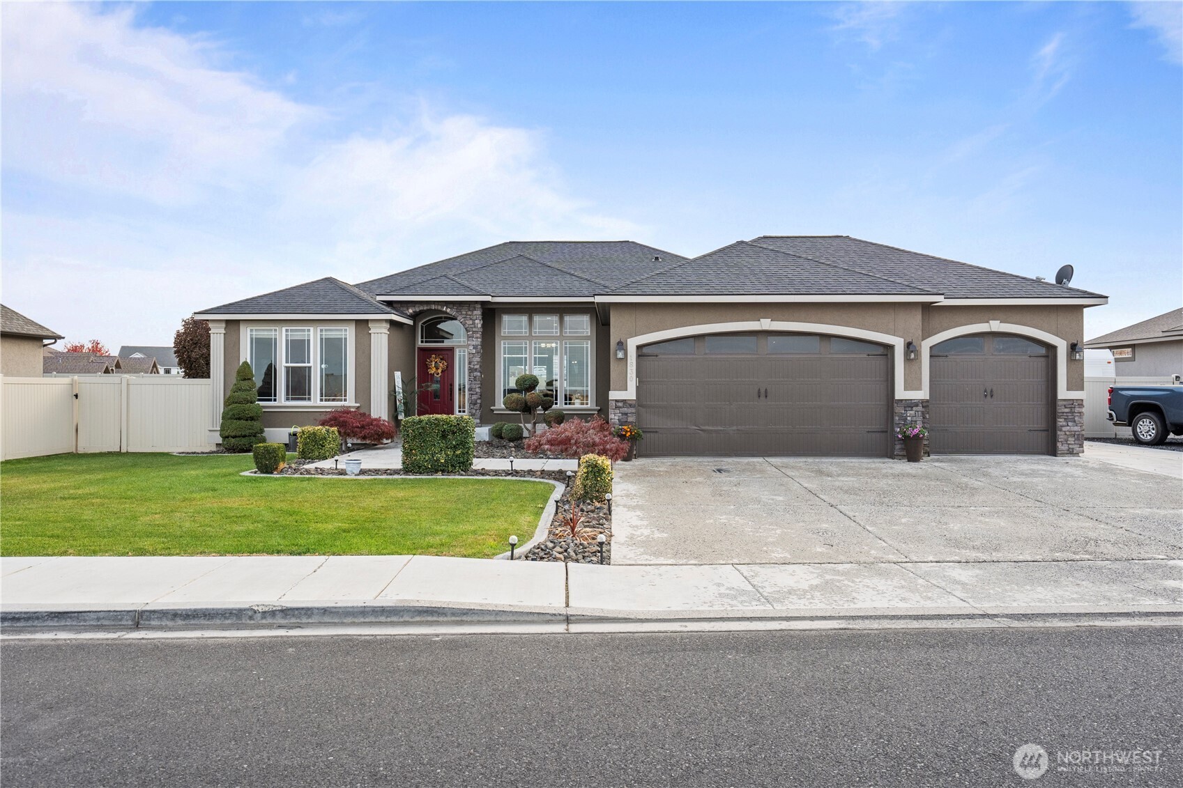 1830 East Madera Street Othello, WA 99344 - Photo 16 of 35 a front view of a house with a yard and garage