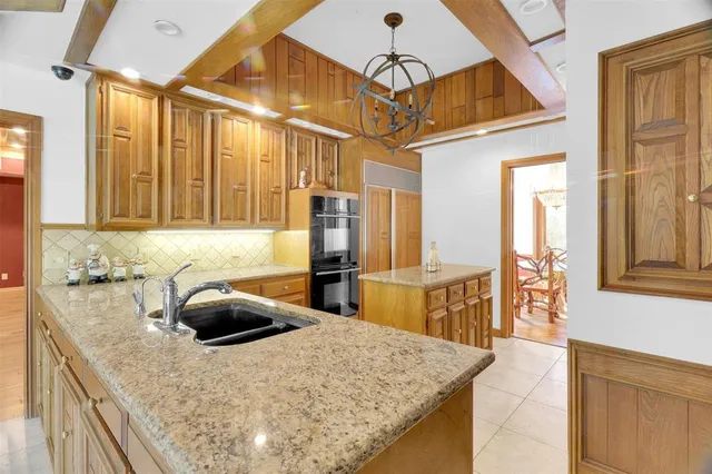 a kitchen with a sink a stove and a wooden cabinets