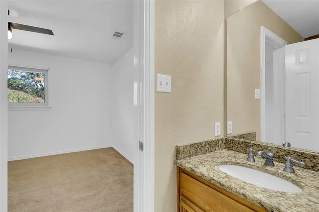 a bathroom with a granite countertop shower and a sink
