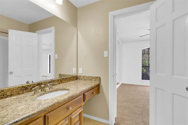an empty room with wooden floor chandelier fan and windows