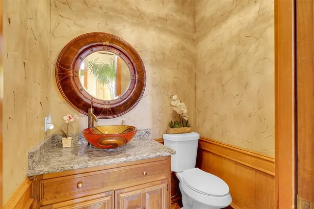 a bathroom with a granite countertop toilet and a sink