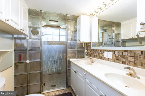 a bathroom with a double vanity sink mirror and shower
