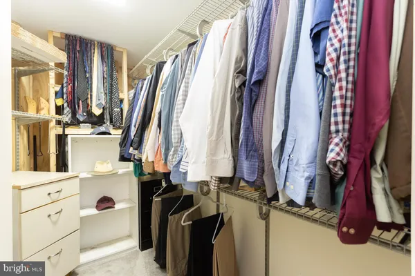 a view of walk in closet with clothes