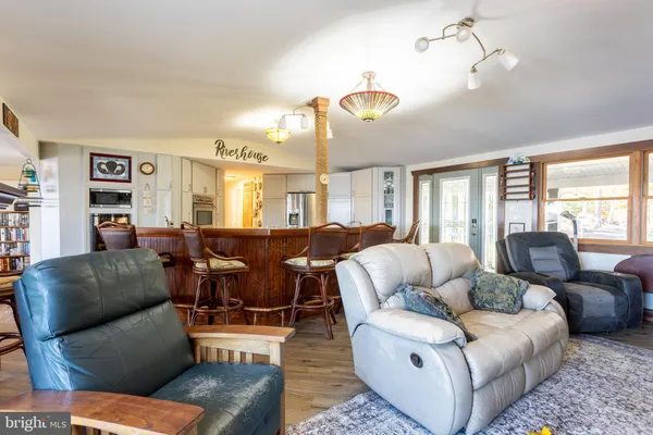 a living room with furniture kitchen view and a chandelier