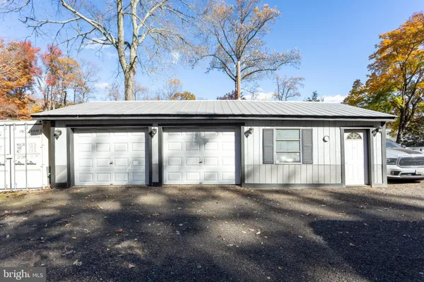 a view of a house with a big yard and large tree