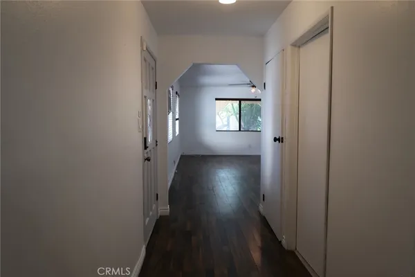 a view of a hallway with wooden floor and a window