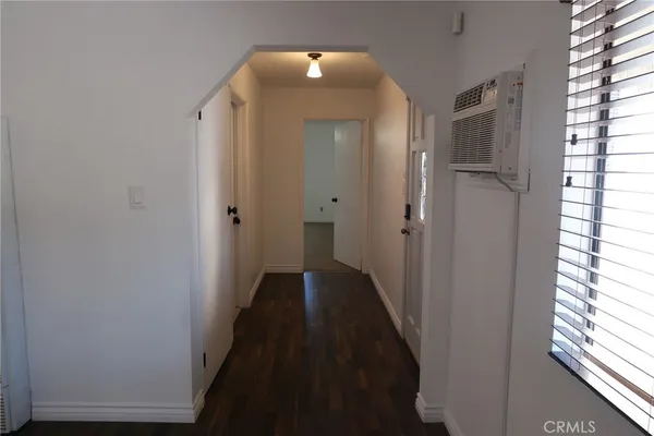 a view of a hallway with wooden floor and closet area