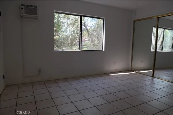 an empty room with windows and closet