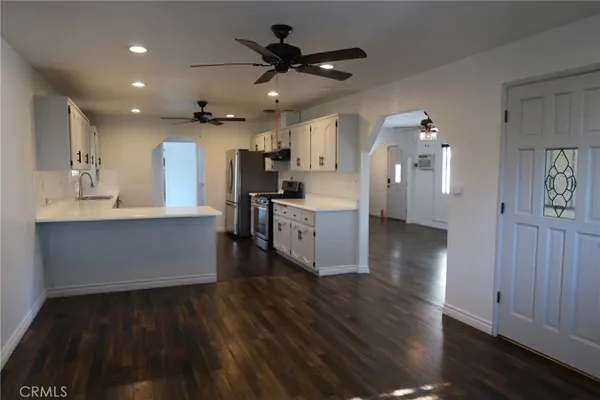 a living room with stainless steel appliances kitchen island hardwood floor and a kitchen view