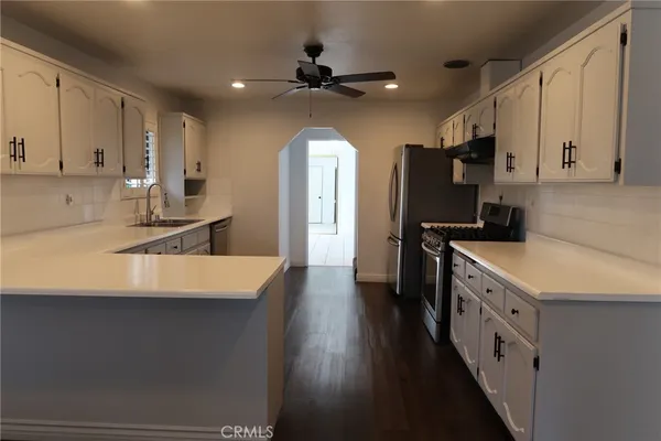 a kitchen with a sink a counter top space stainless steel appliances and a window