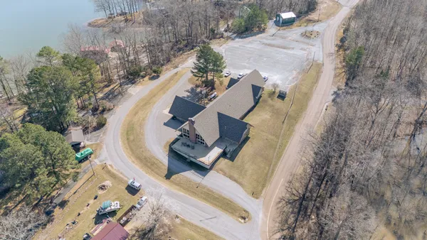 an aerial view of a house with a yard and lake view